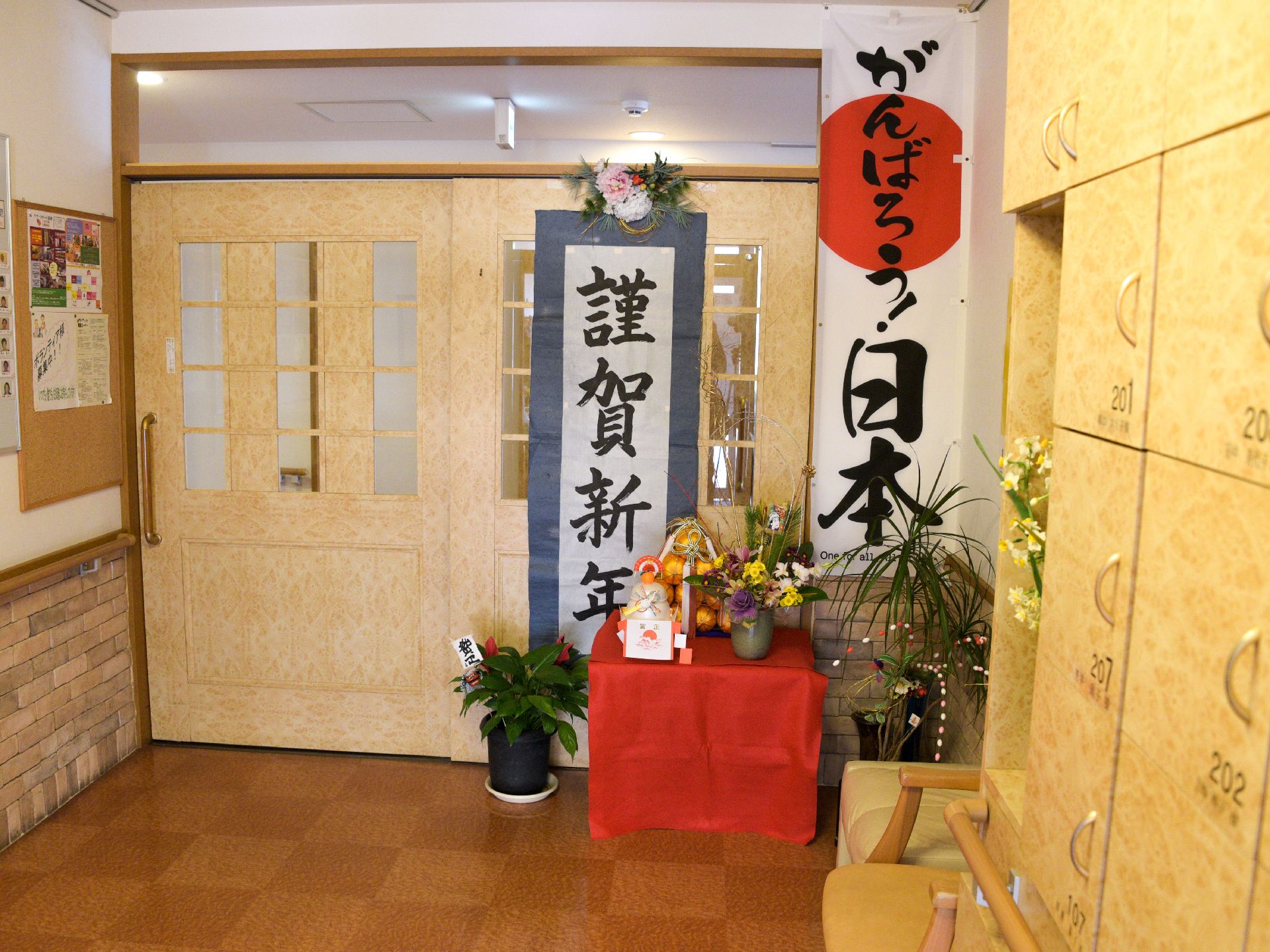 扉には「謹賀新年」と書かれており、お餅などが置かれている。黄色い下足入れが置かれ、周囲には手すりや椅子が置かれている。