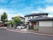 グレーの屋根が付いた２階建ての建物は一般の住宅のような外観。敷地内の駐車場には車が止まっている。