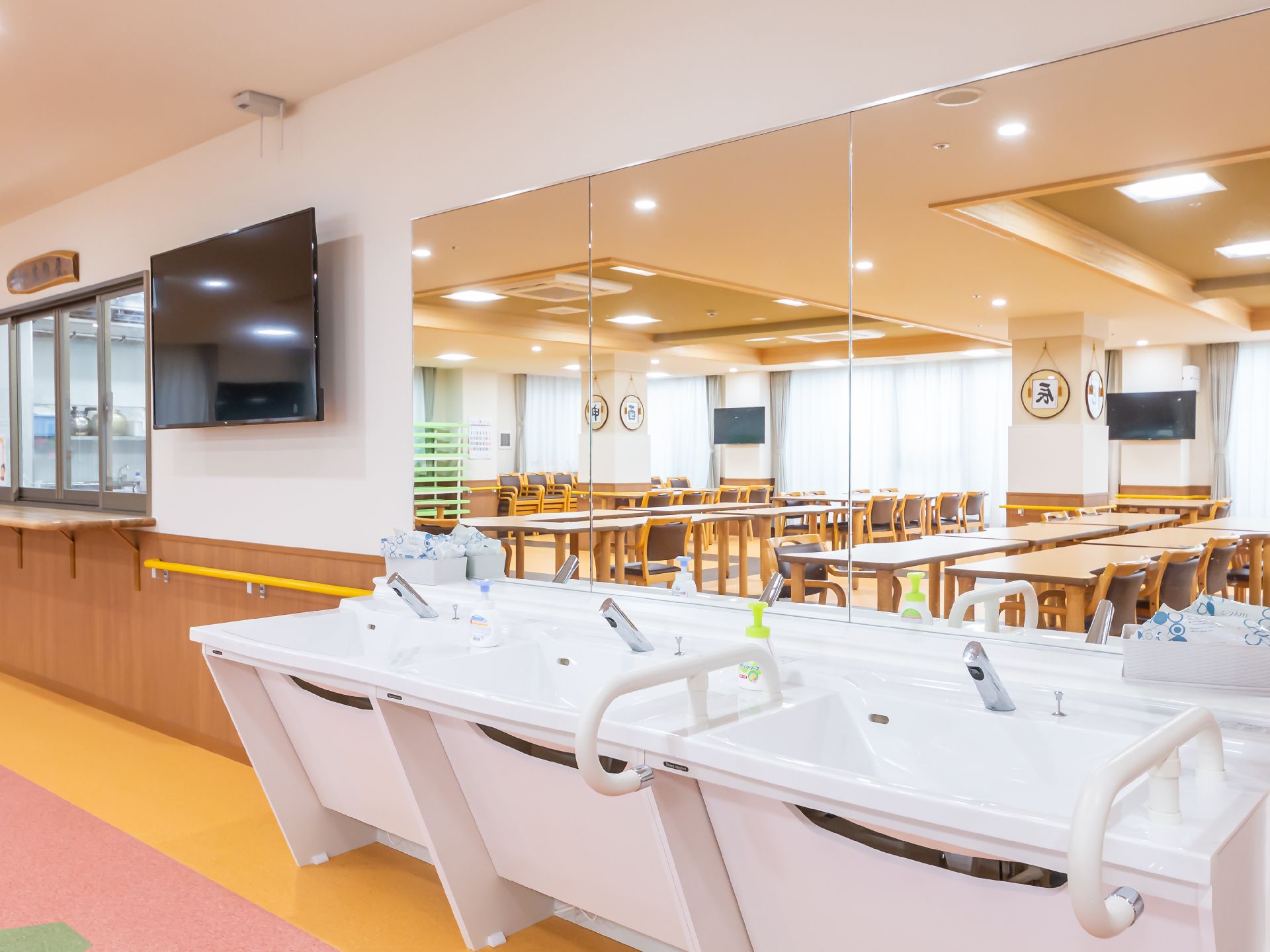 大きな鏡と手すりを設置している洗面台