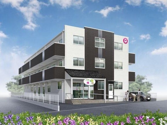 白とダークグレーを基調とした３階建ての建物は各フロアにベランダがあり、敷地内には駐車場もある。