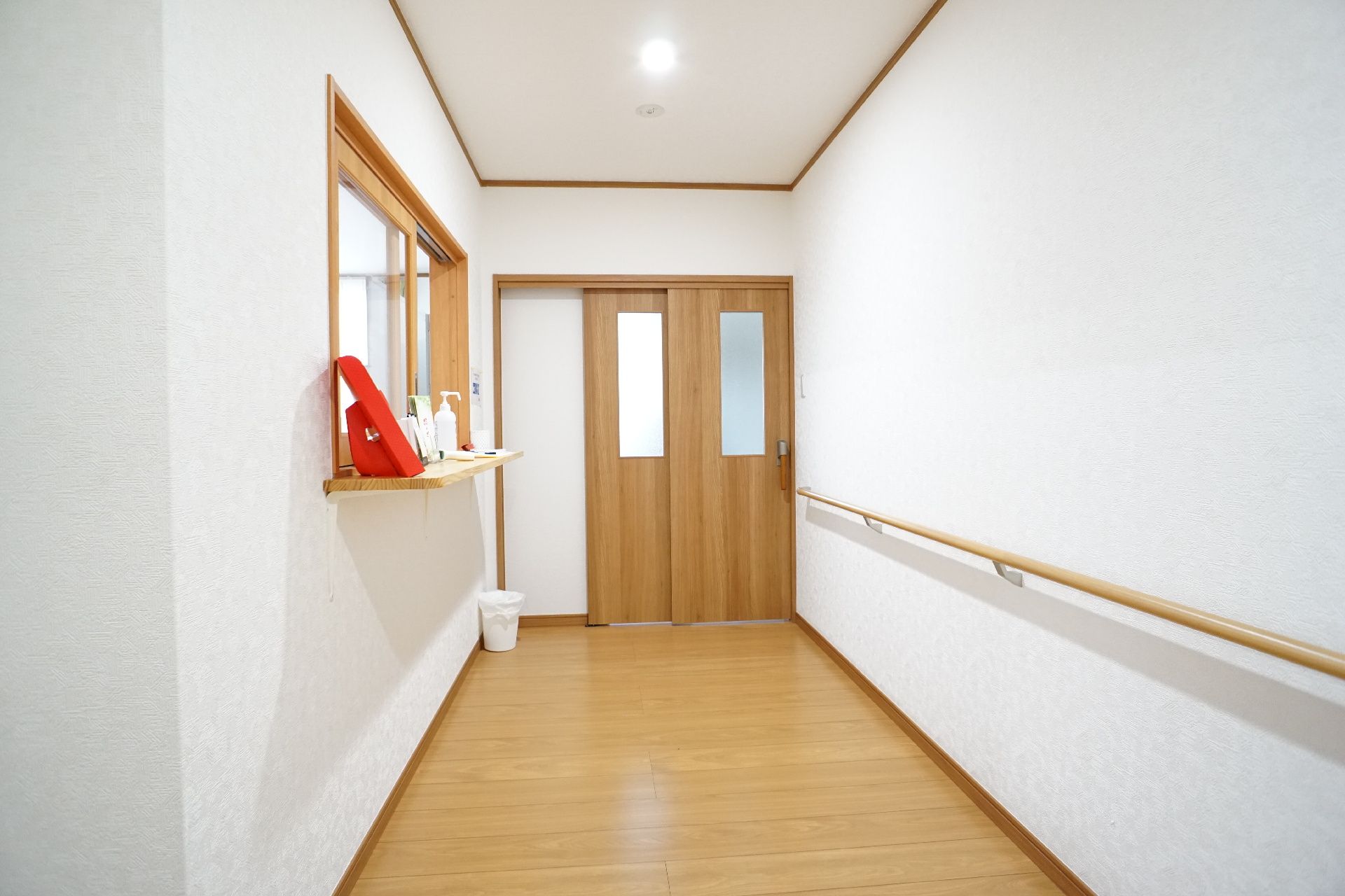 受付が近くにあり、手すりが設置してある廊下