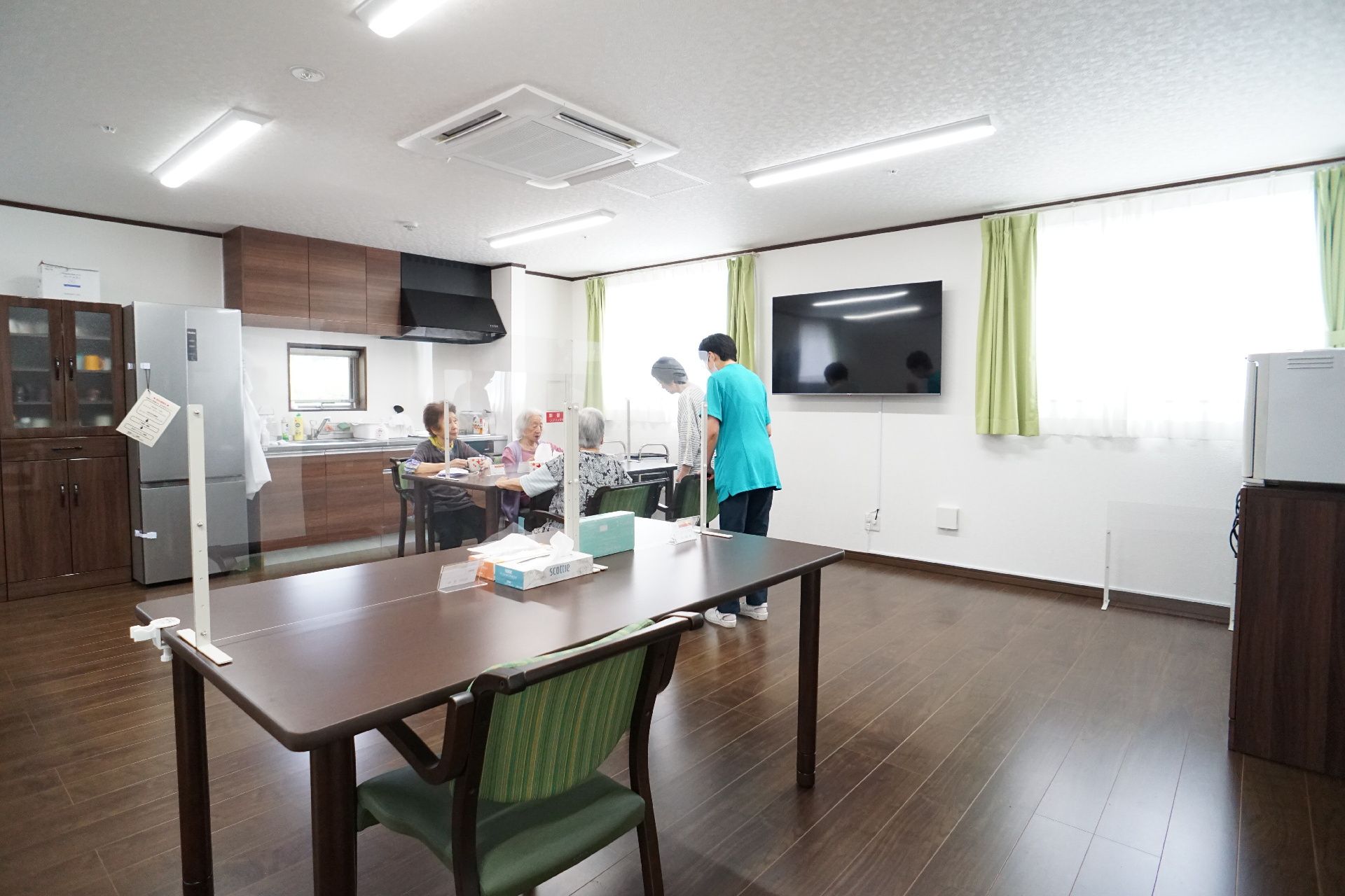 窓から光が差し込み、テーブルや椅子、キッチンが置かれている共有スペース