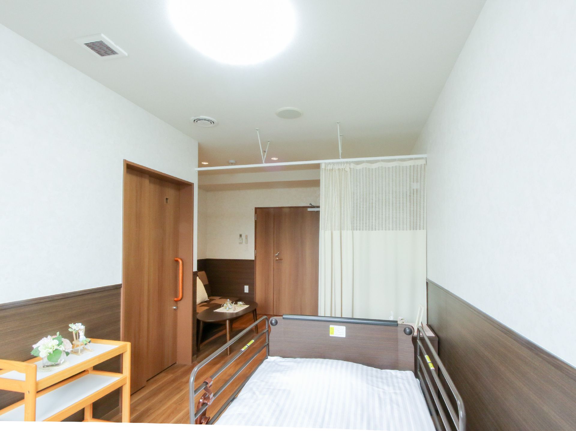 ベッドが置かれた白い壁の部屋
