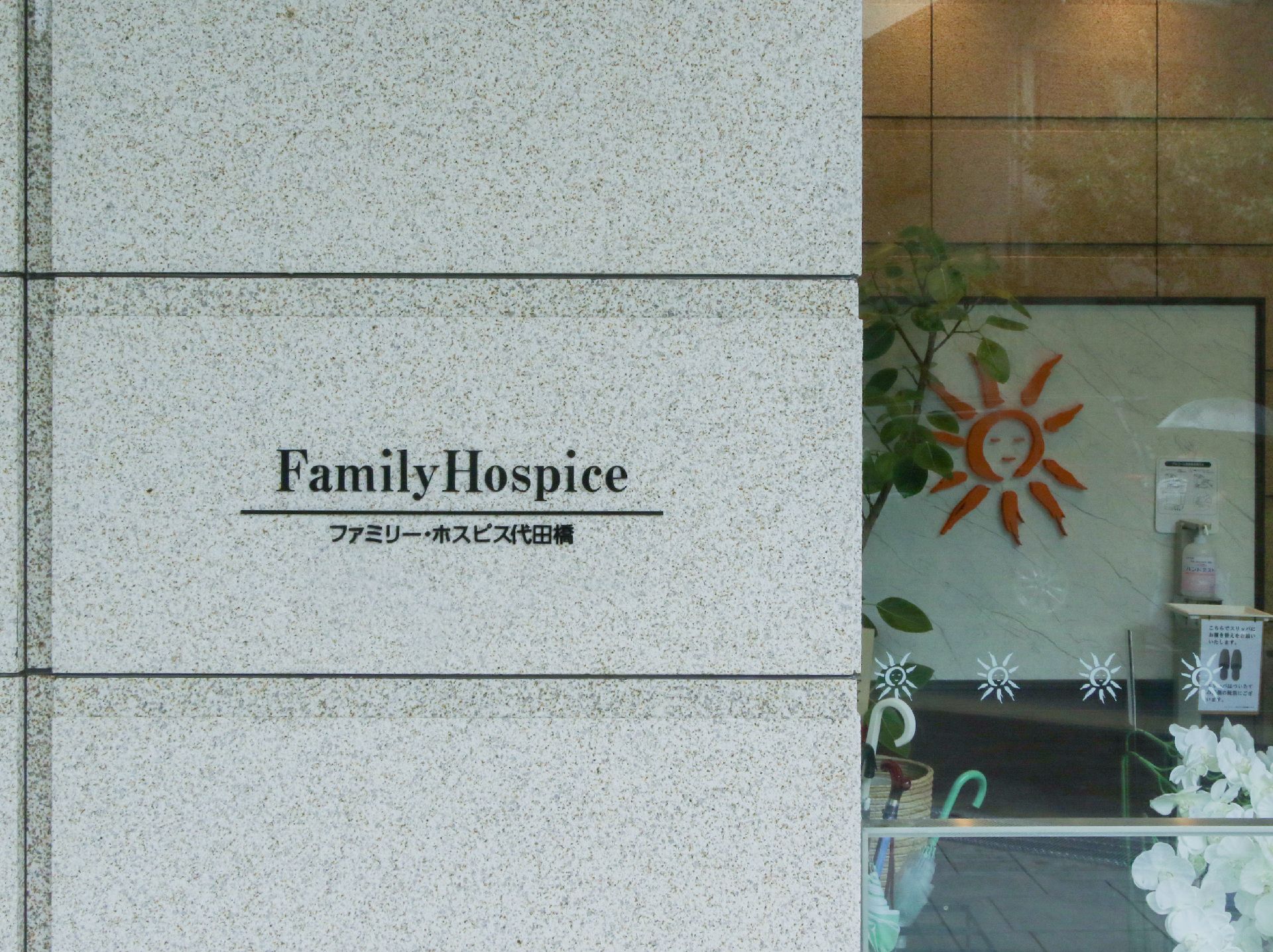 建物の石でできた柱を装飾するFamily Hospiceの文字