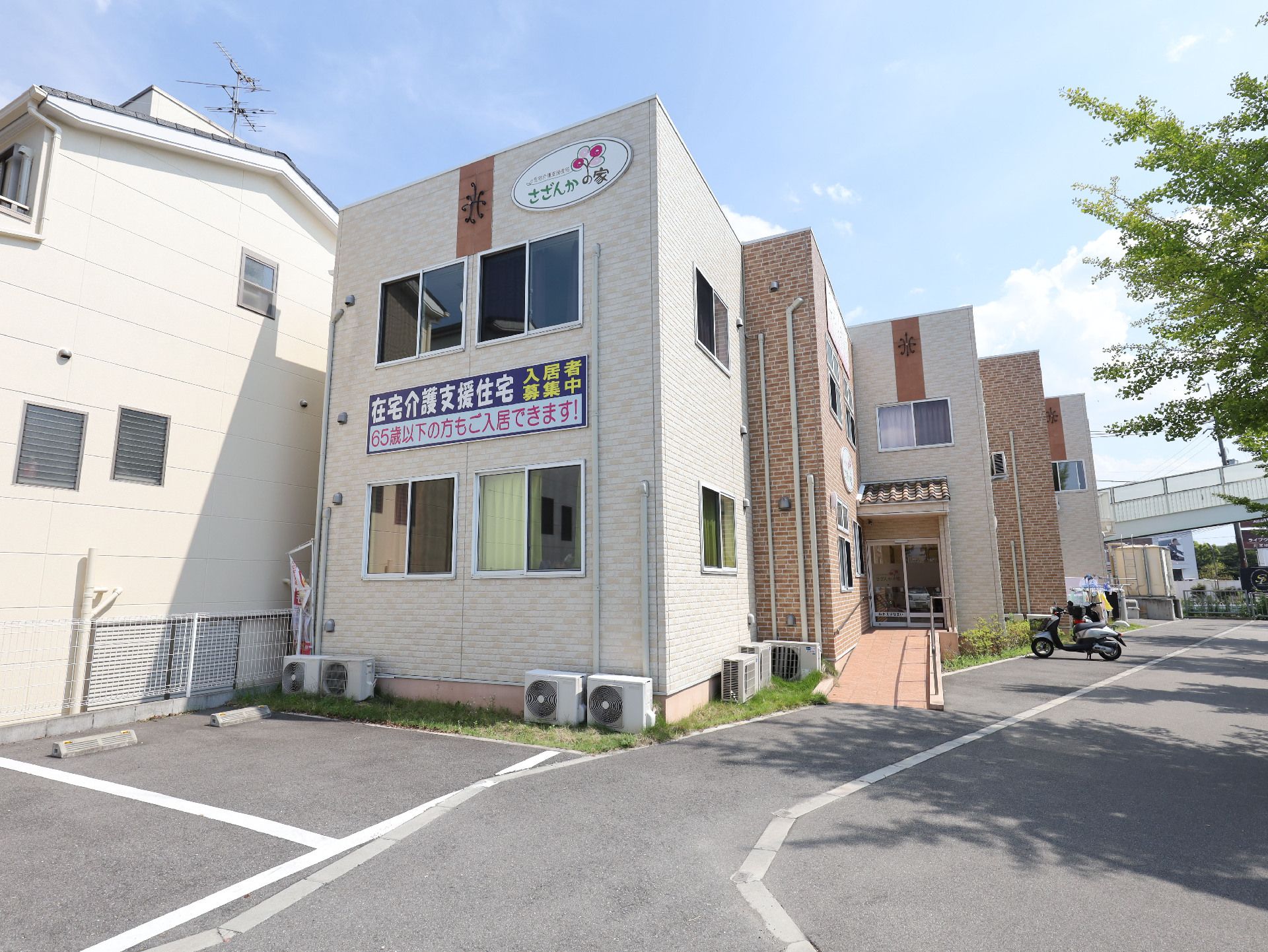 アスファルトの道路沿いに立地している白い外観で２階建ての建物