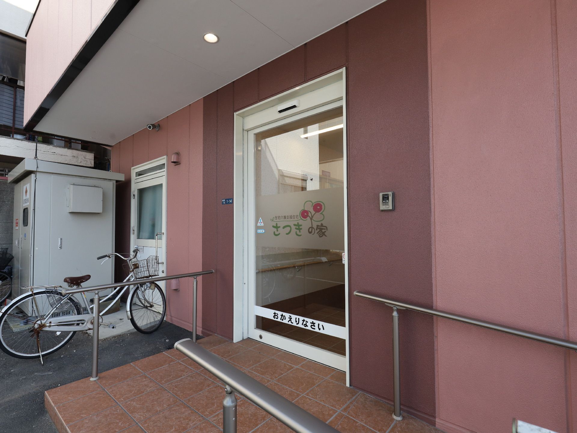 ピンクの建物の自動ドアが付いた入り口