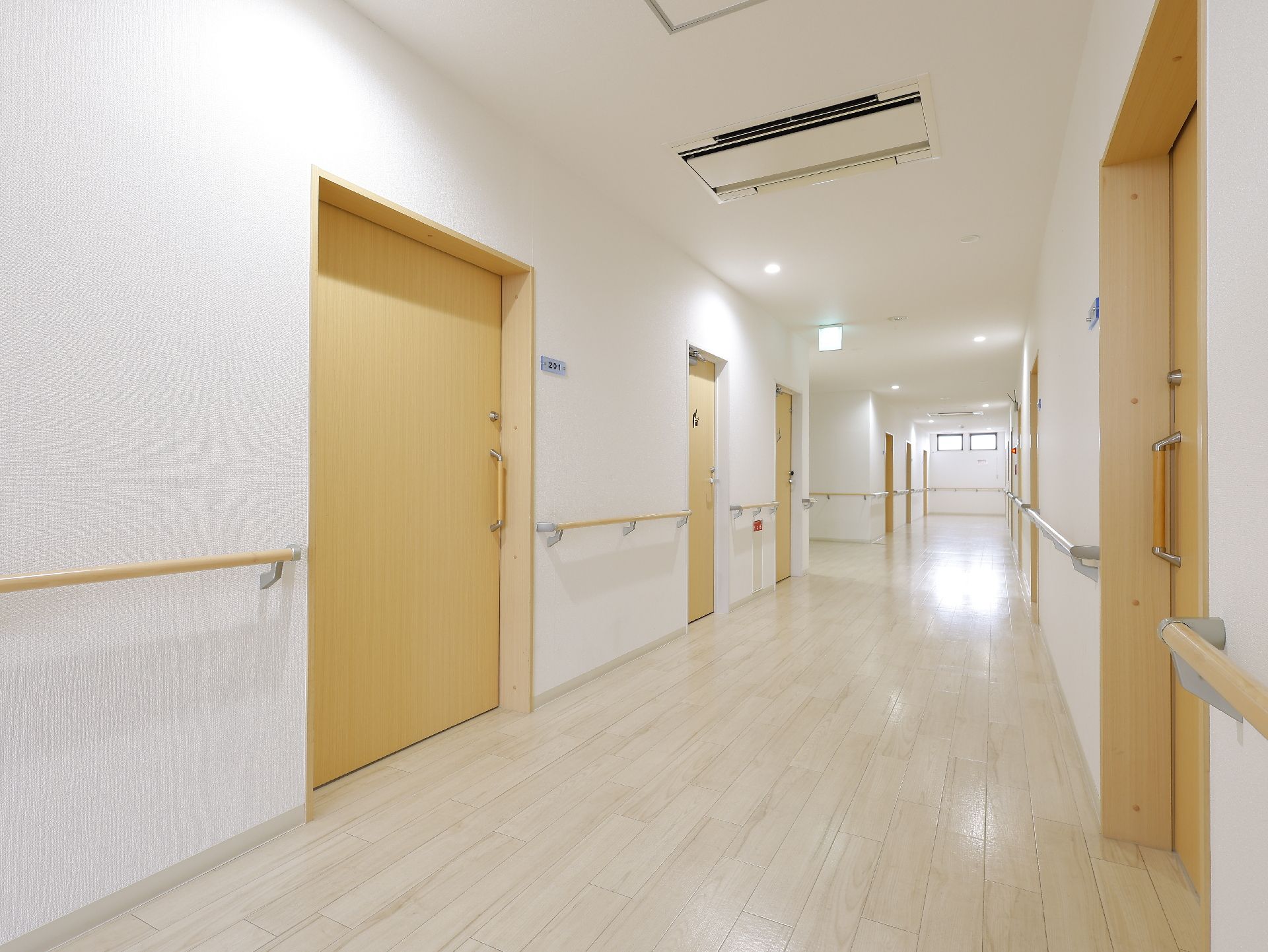 手すりが行き渡っている廊下と、引き戸となっている居室