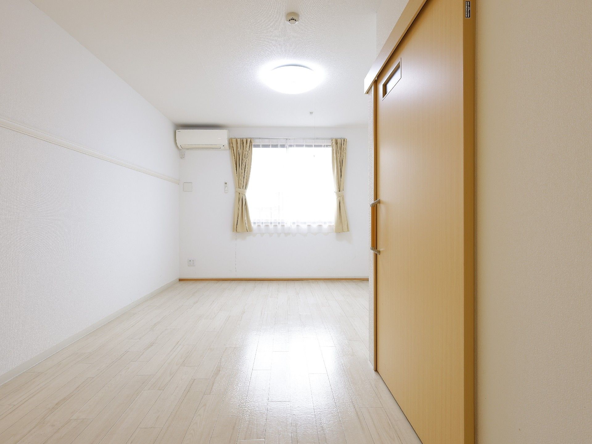 なにかを見て笑顔で手をたたいている高齢女性とスタッフの様子。施設での一場面の写真