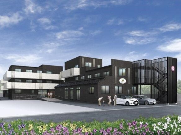 敷地内には駐車場があるダークグレーを基調とした３階建ての建物は玄関には手すり付きのスロープがある。