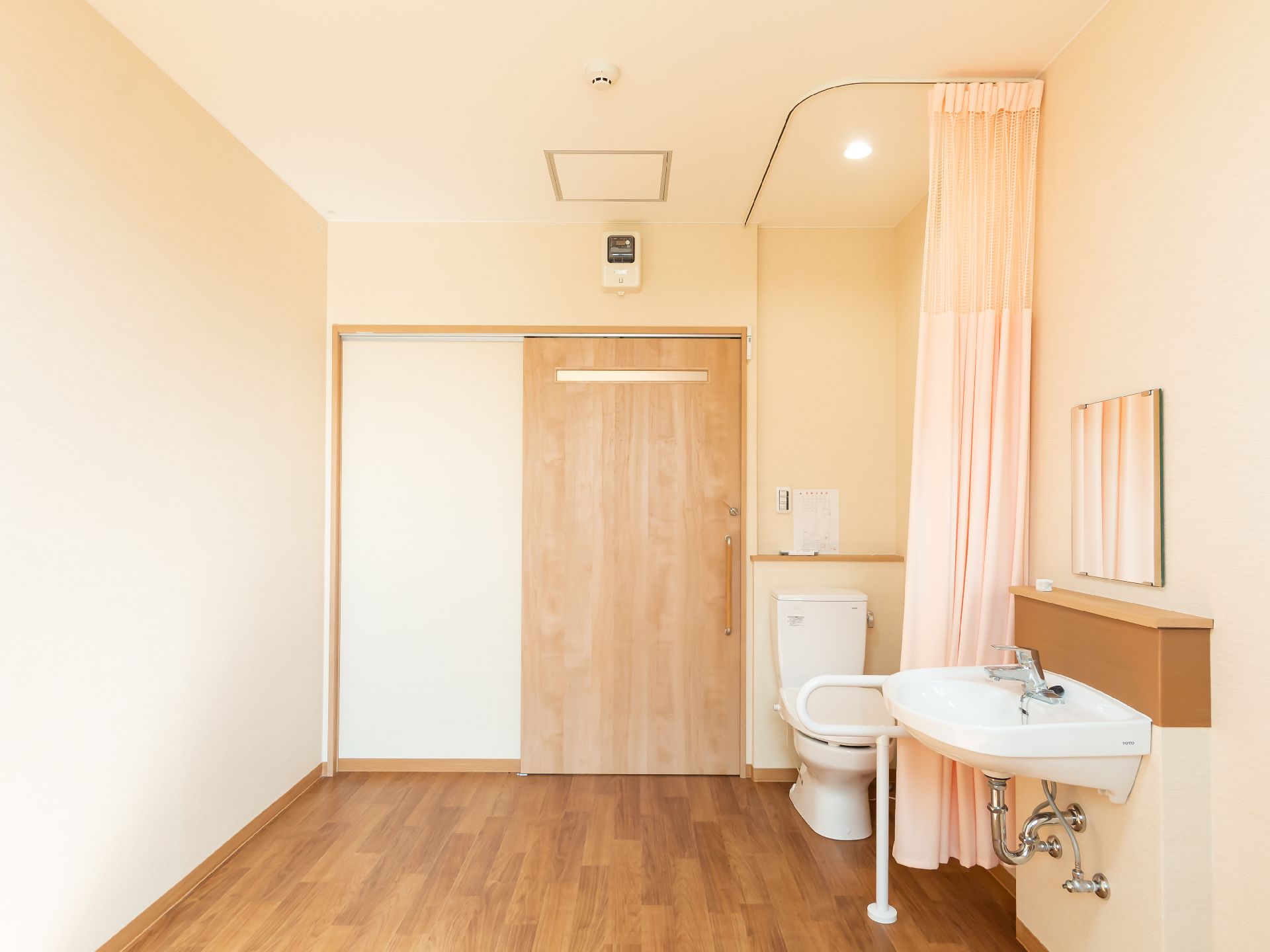 洗面台と洋式便器が並べられた白い壁の部屋