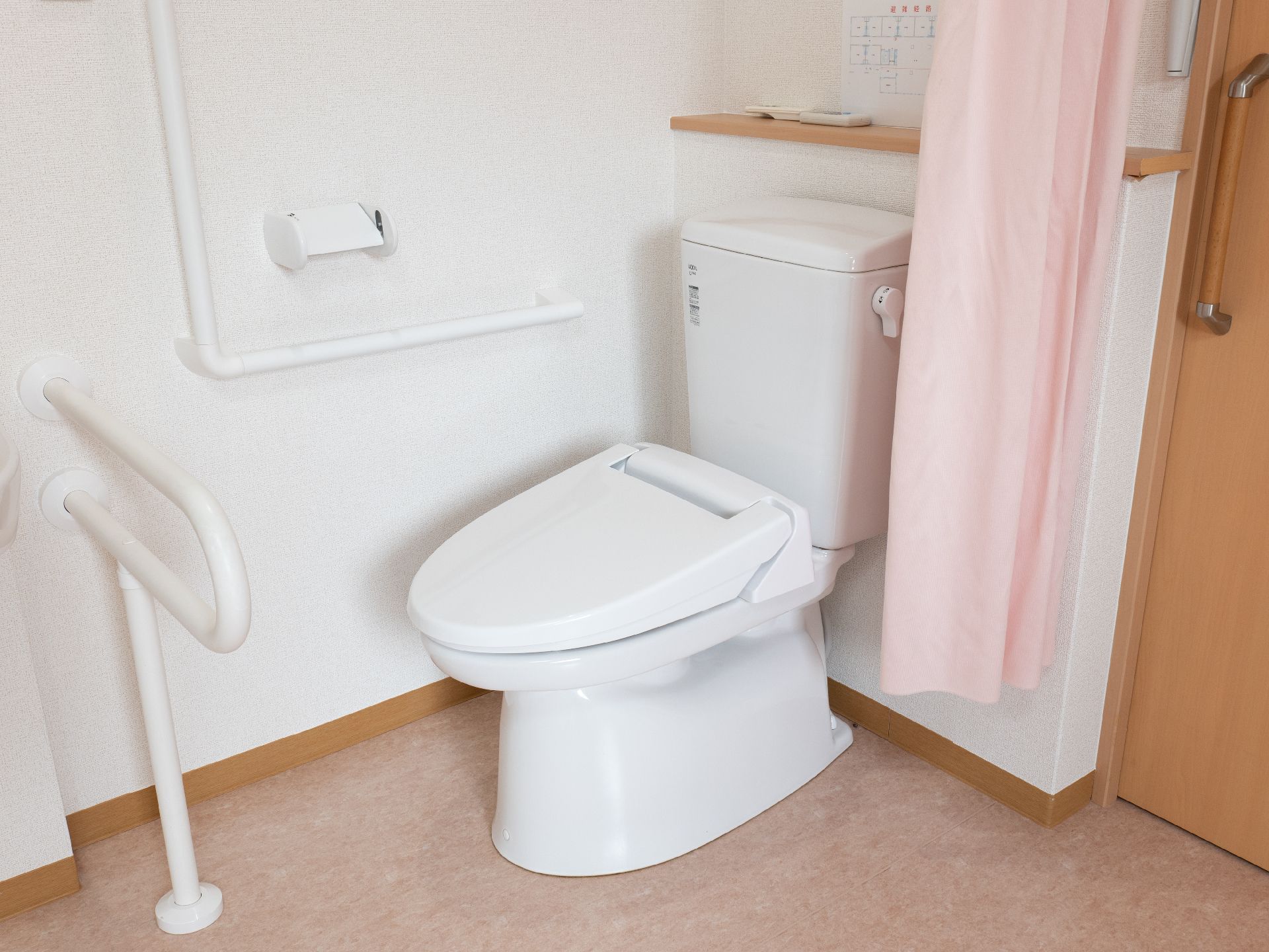高齢者でも楽に座ることが可能な、手すりのついたトイレ