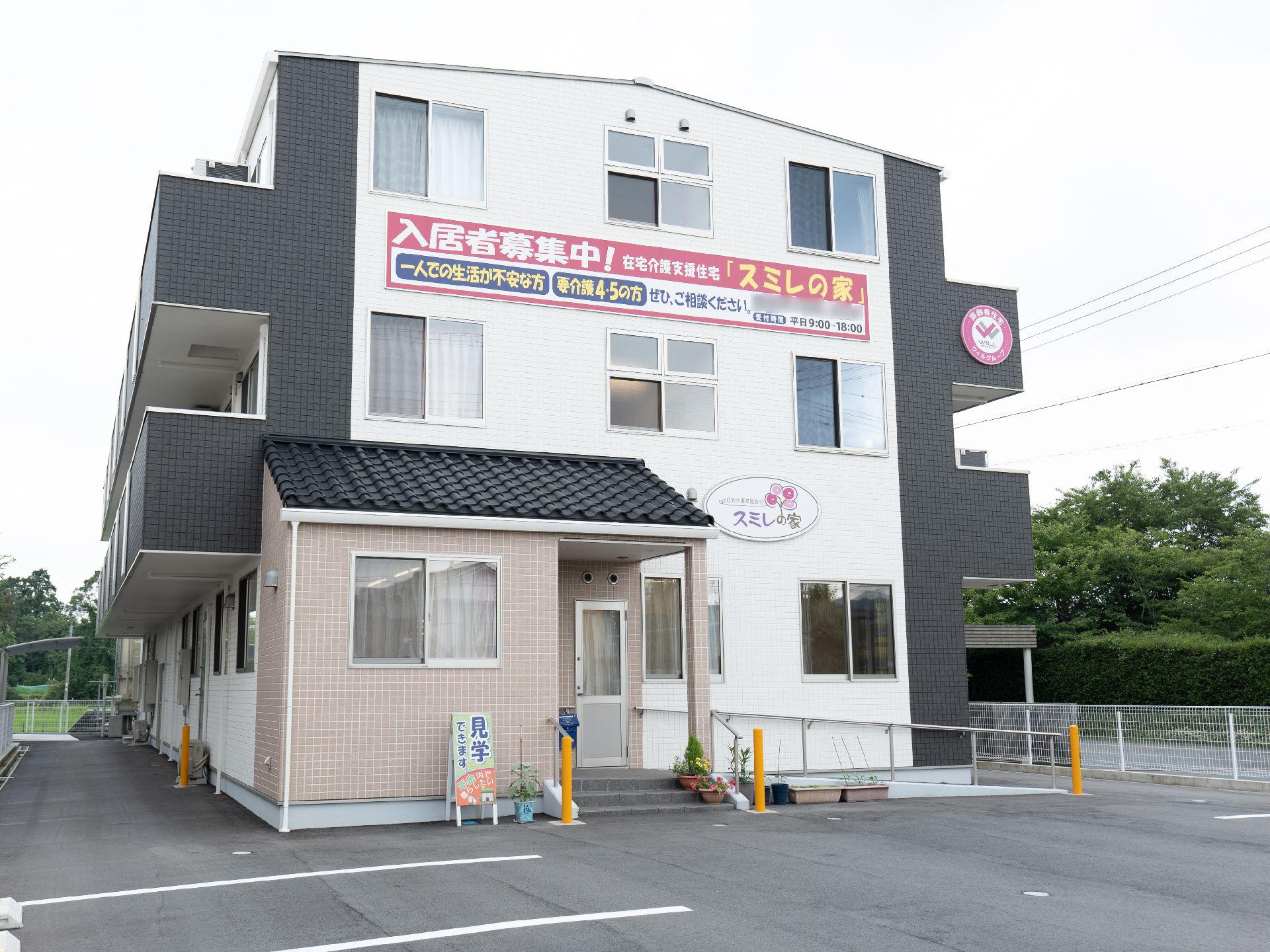 落ち着いた色合いで、マンションのような形状の介護施設の外観