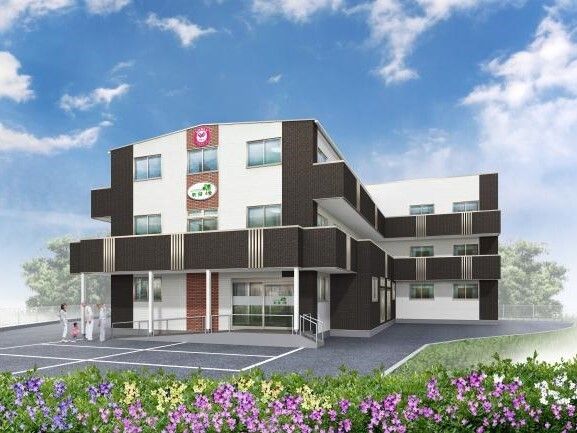 ３階建ての建物は白とダークグレーで敷地内には駐車場があり、日当たりのいい場所に建っている。