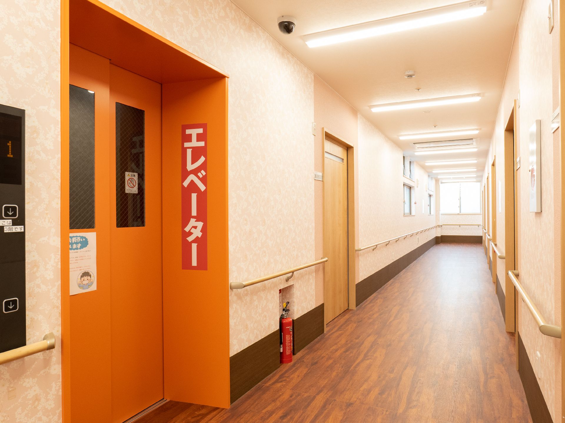 両側の白い壁に木製の手すりが付いている廊下