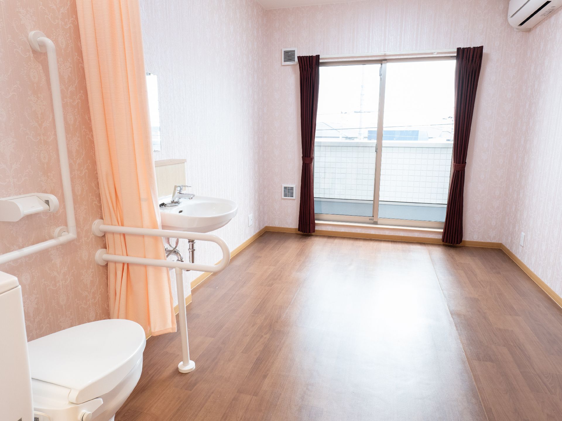 大きな窓が付いたトイレと洗面台が配置されている部屋