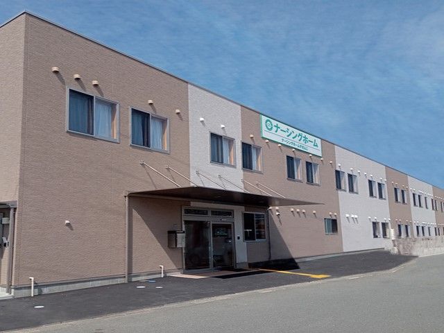 ナーシングホームすせんじの看板があり、ベージュと薄茶の外壁の2階建て老人ホーム