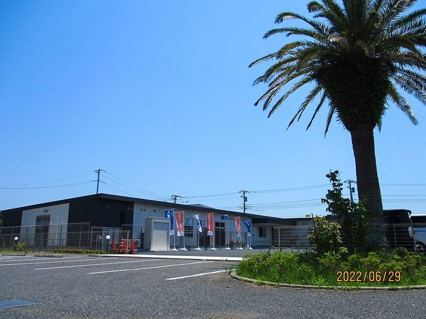 広い駐車場が付いた平屋建ての建物はまわりにたくさんののぼりが立っていて青い空が広がっている。