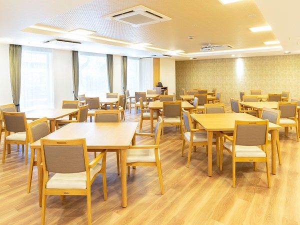 木製のテーブルと椅子が複数並べられた広い空間
