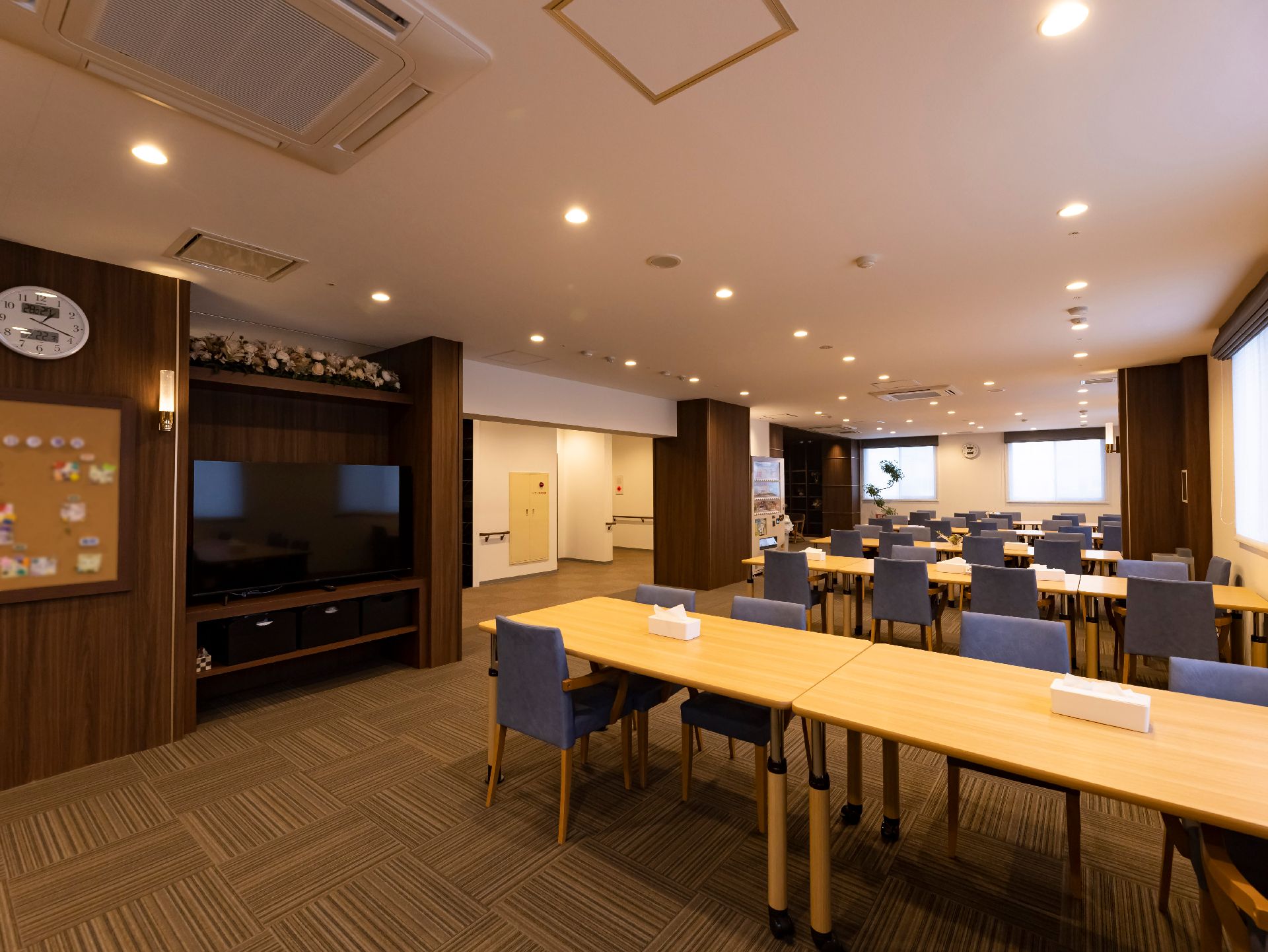 大きなテーブルとテレビがあり広い空間の食堂