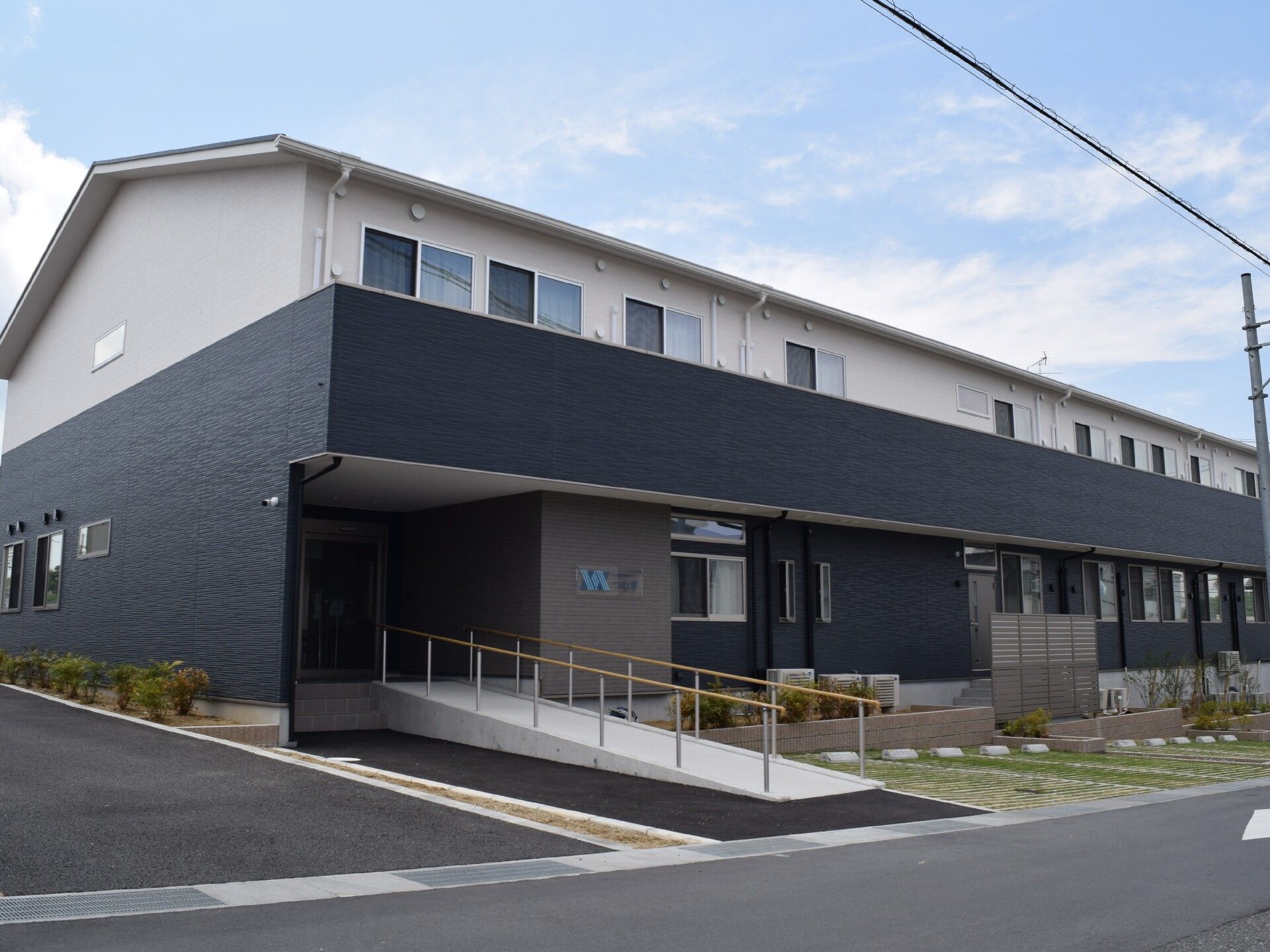 なにかを見ながら談笑しているスタッフと高齢者の様子。施設内の会話の場面