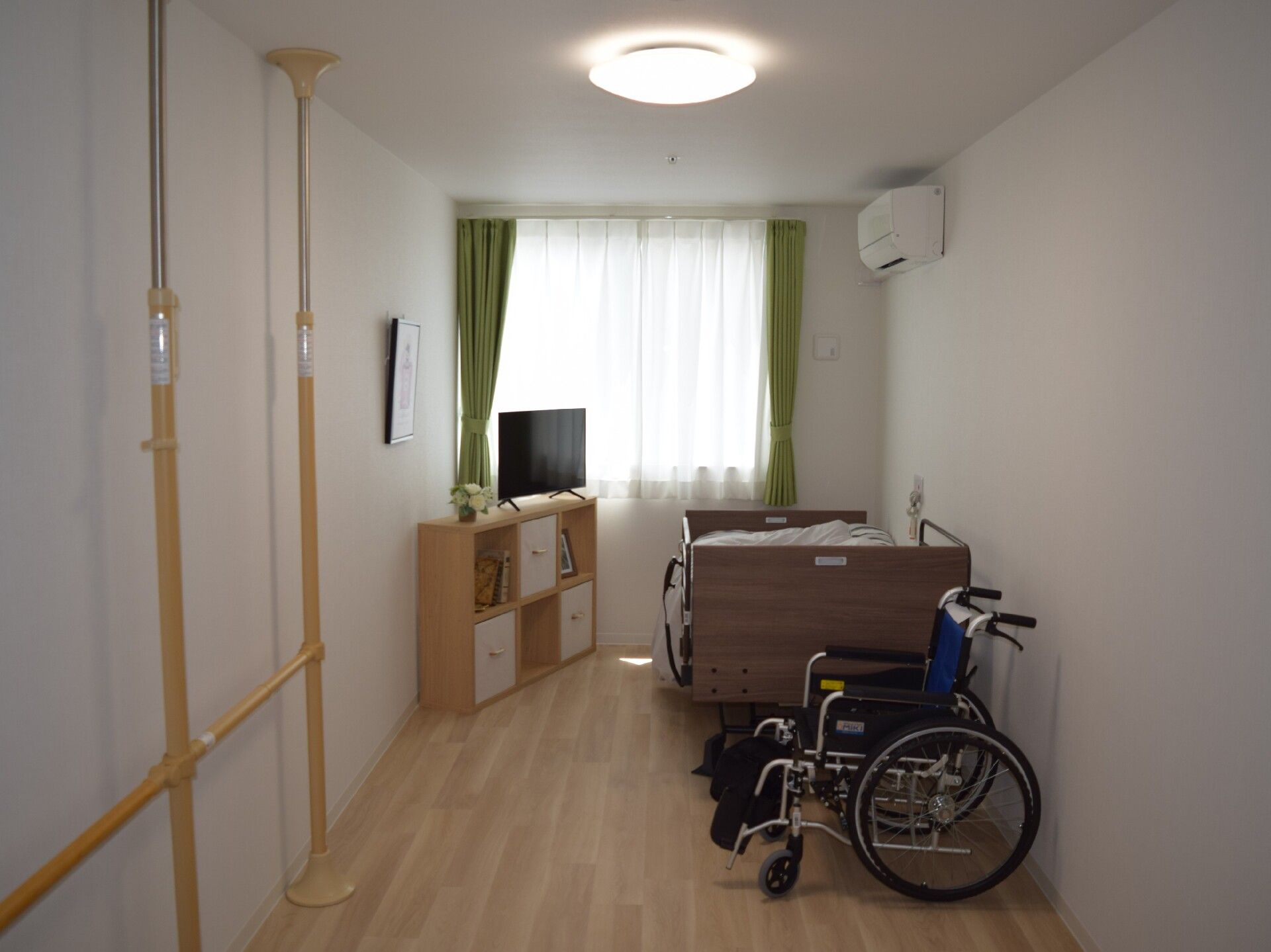 車いすから立ち上がろうとしている男性とそれを補助しようとしている女性スタッフの様子