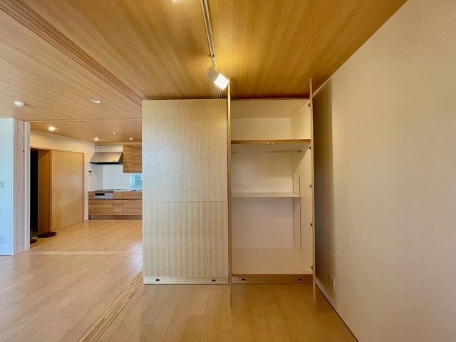 仕切り代わりとしても役立つ位置に設置された収納家具。奥には本確定なキッチンも付いている。