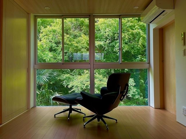 エアコンが付いたフローリングの部屋にはゆったりとくつろげるオットマン付きのリクライニングチェアがある。