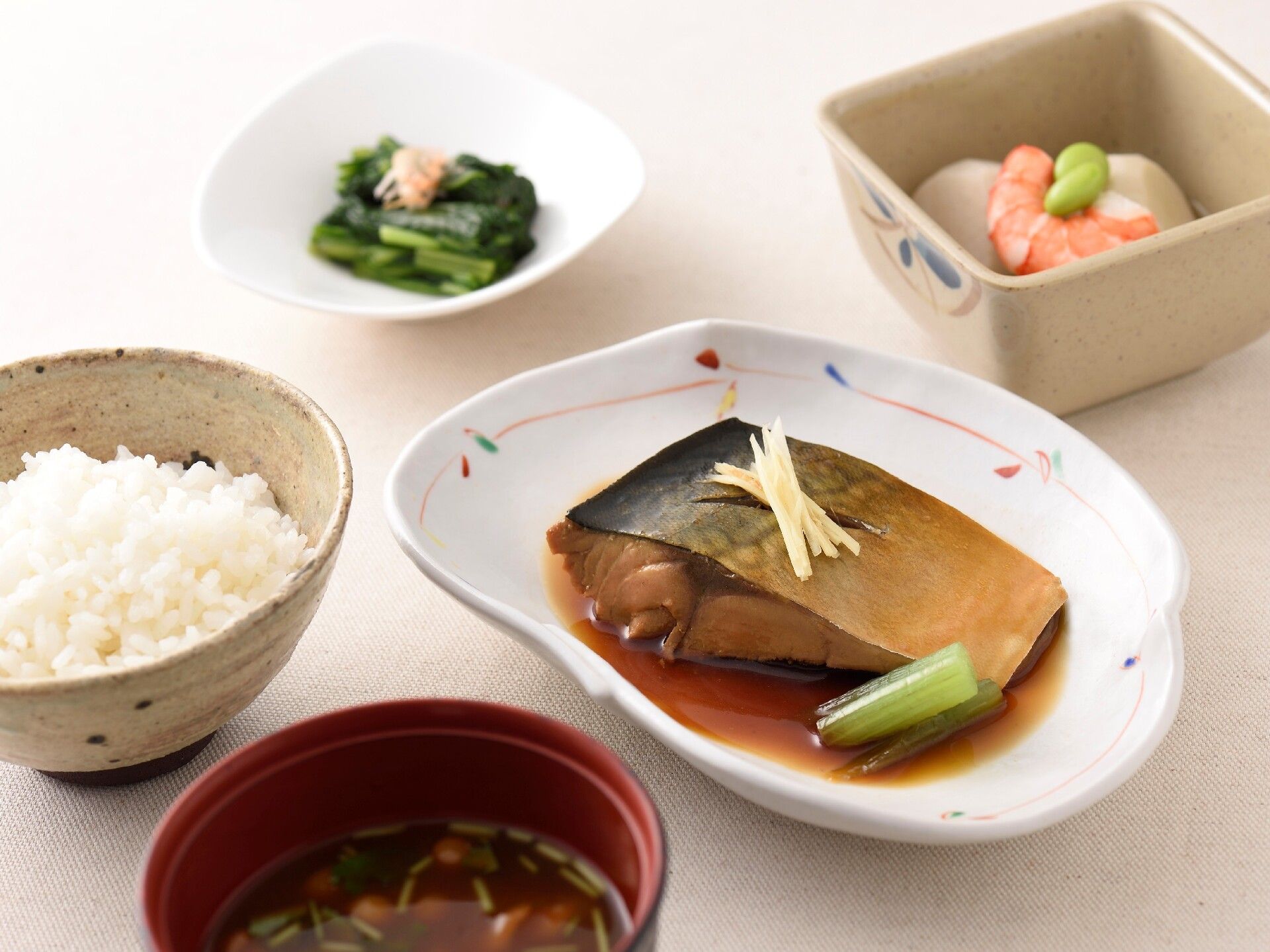 白い皿にサバの味噌煮と小鉢に副菜が盛り付けられている
