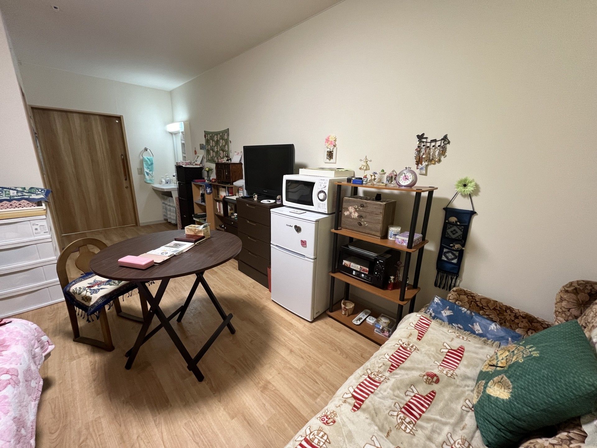フラワーアレンジメントを楽しんでいる眼鏡をかけた高齢男性とエプロンを付けた若い女性スタッフ。