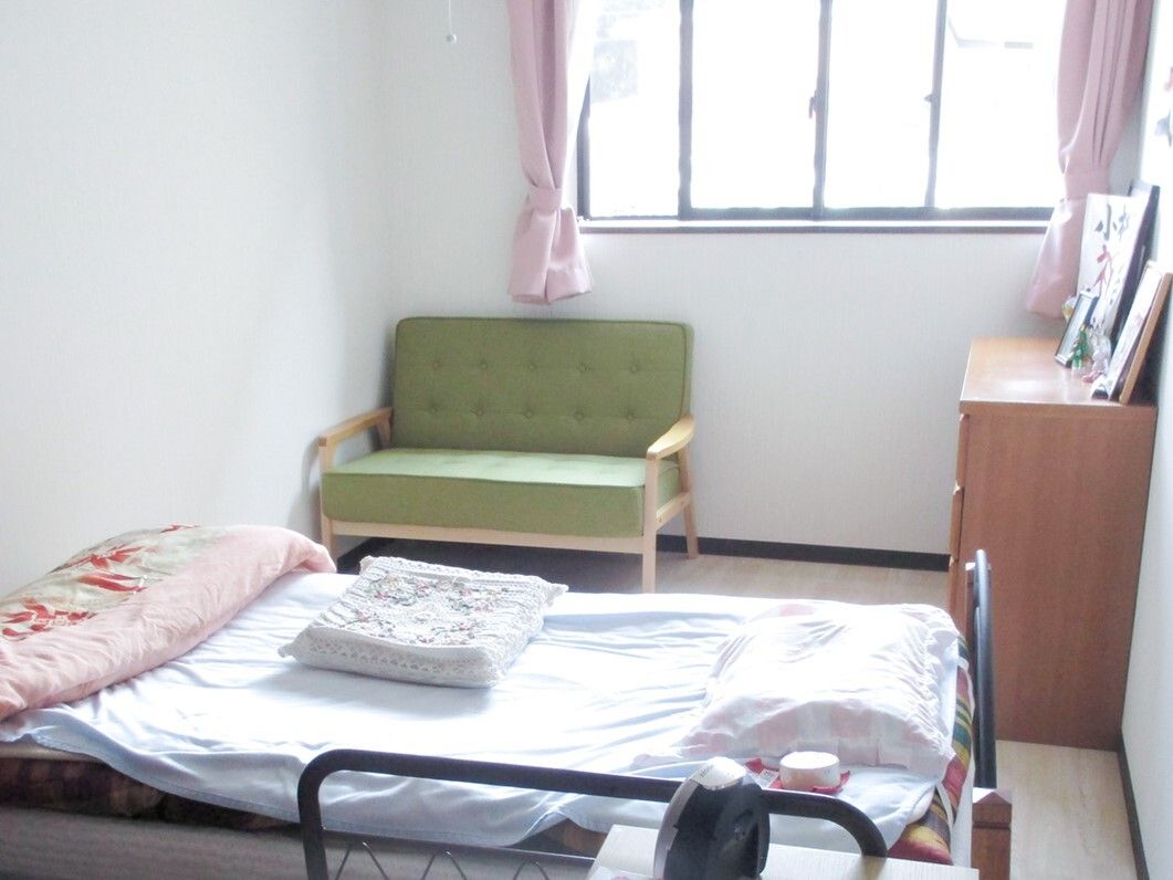 大きな窓が付いた部屋には寝具付きのベッドやタンス、ソファなどが置かれていて、日当たり良好。