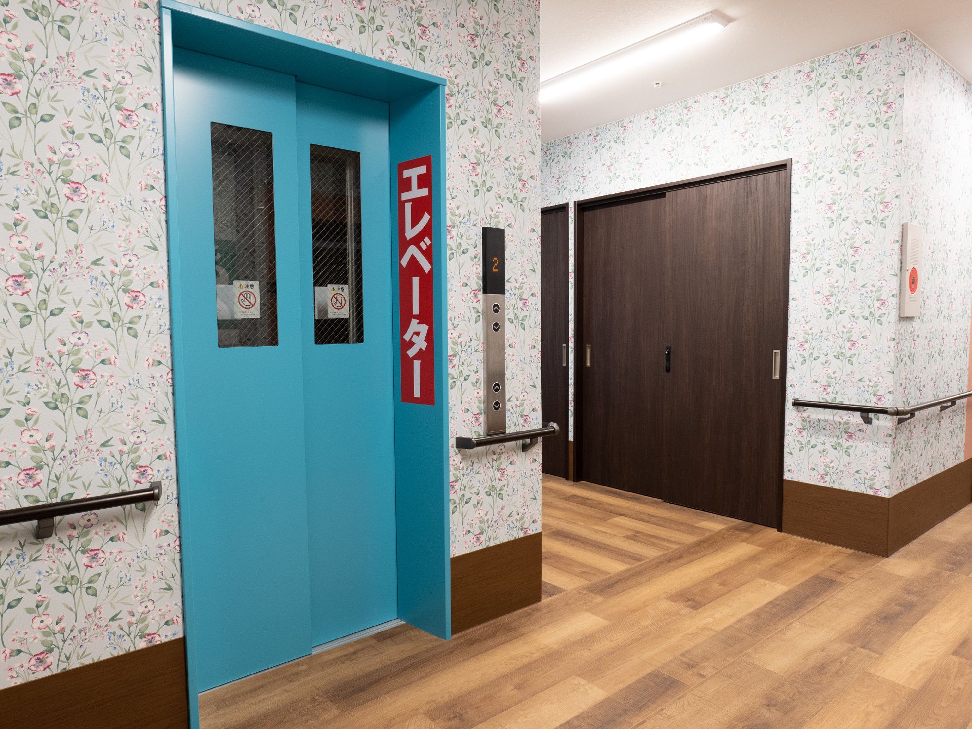 明るく華やかな花柄の壁紙がある館内