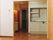 白を基調としたミニキッチンが付いたフローリングの部屋。手前のリビングスペースもフローリング。