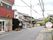 赤い屋根のベーカリーの入り口には草木が植えられた鉢が置かれ、自動ドアには店名が書かれている。