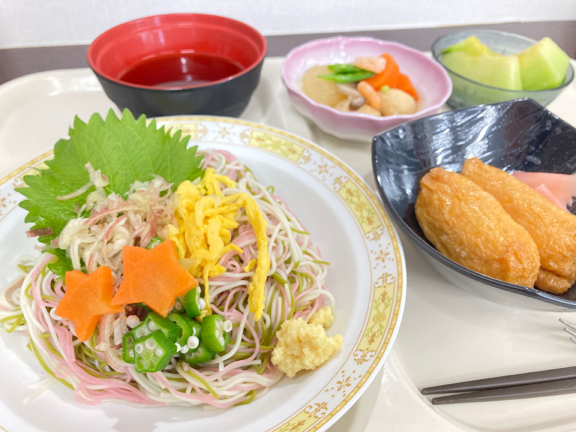 シソが添えられた七食そうめんにはおくらや星形のニンジンなどが添えらえ、稲荷寿司やメロンなどもある。