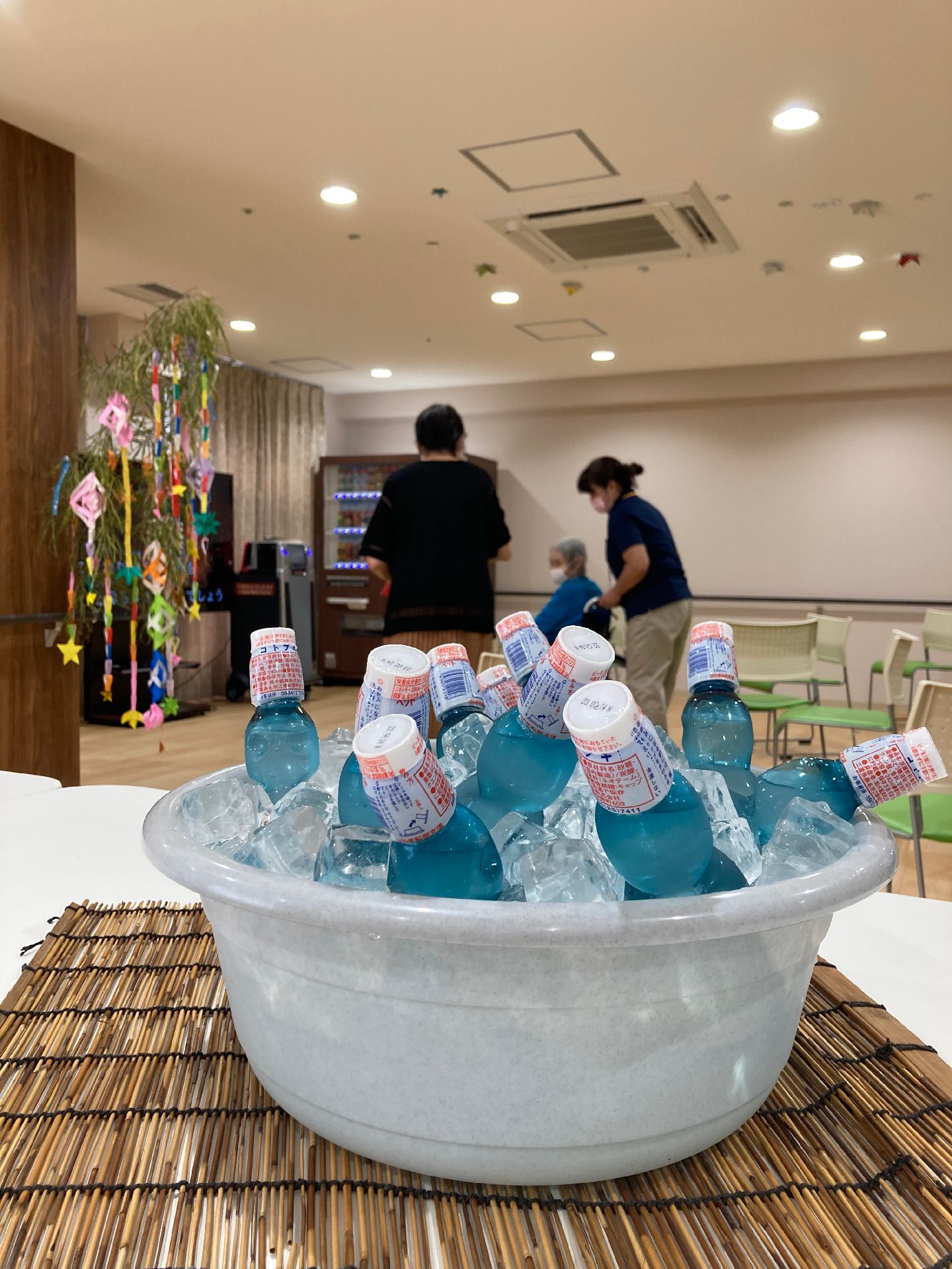 洗面器の中にはたくさん乗ら旨の便が詰められている。その奥には七夕飾りが飾られた笹がある。