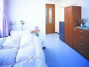 クローゼットやタンス、寝具付きのベッドが置かれた部屋は明るい雰囲気。花も飾られている。