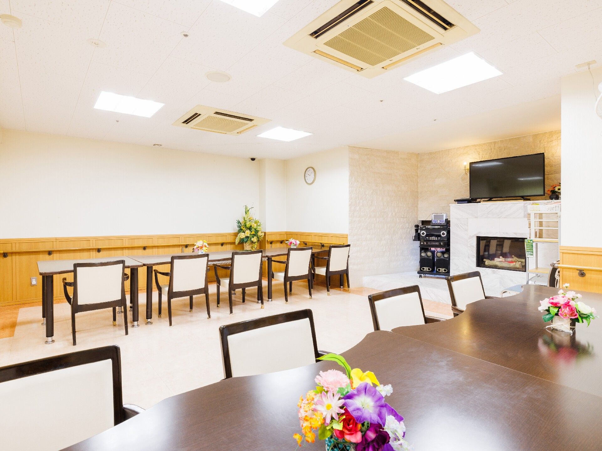 レースカーテンとカーテンが付いた大きな窓がある広い部屋にはトイレや洗面所も付いている。