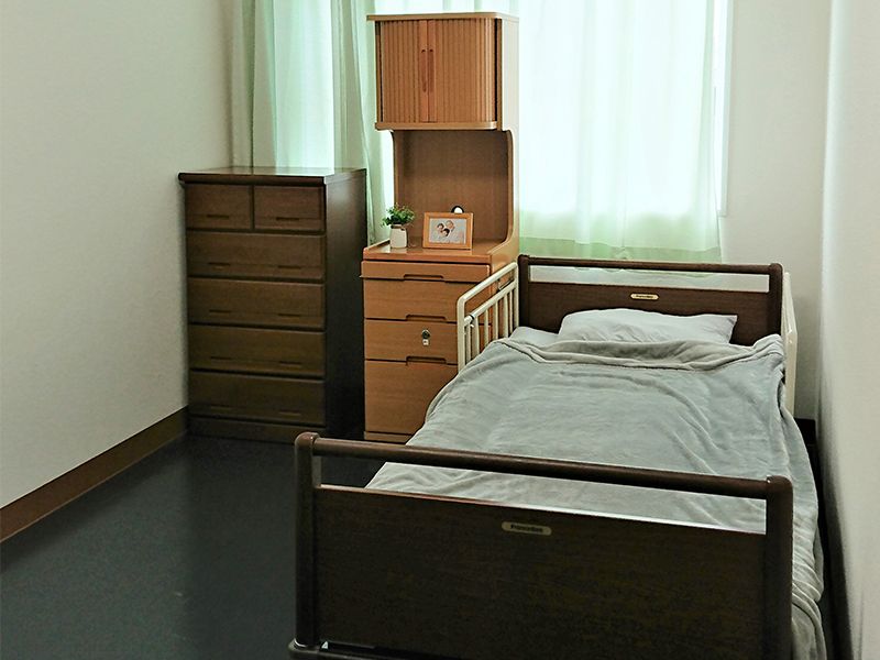 寝具付きのベッドやタンスなどが置かれた部屋には草木や絵も飾られている。