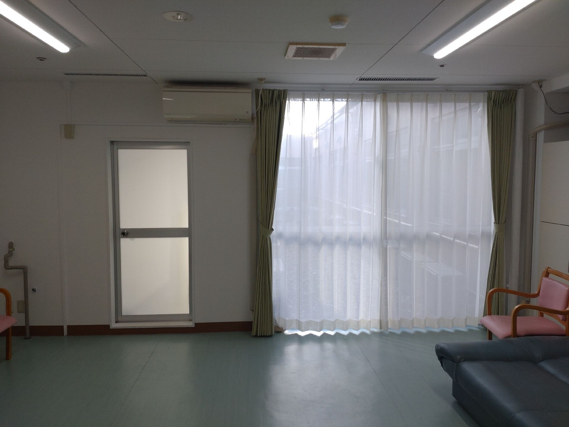入居者の塗り絵のようなものがたくさんテレビの横の壁に貼られている。テーブルセットもある。