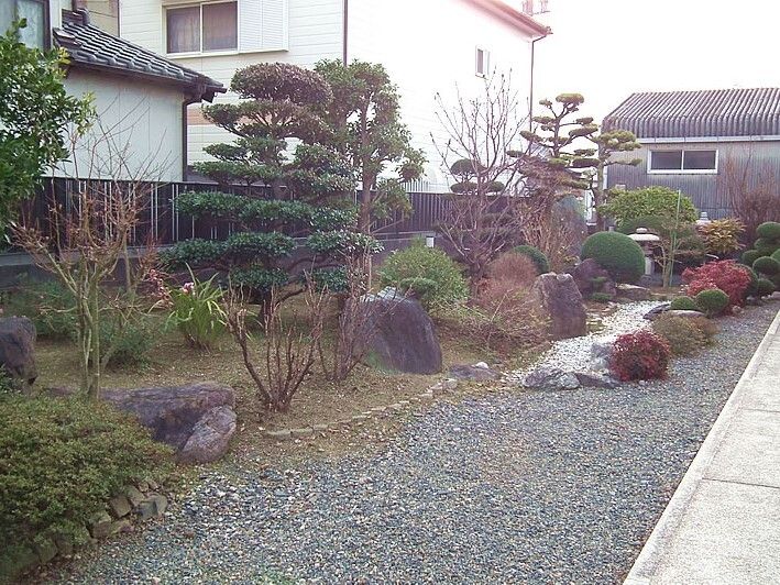 背の低い木はきれいに丸く剪定されていて、大きな石も所々に置かれている和風の庭園。