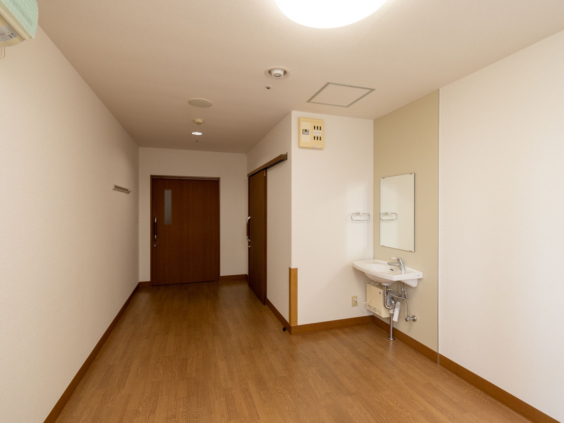 介護ベッドや収納棚、椅子が設置された居室