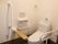 低い位置に設置されたオレンジの呼び出しボタン。トイレの両サイドには複数の手すりがある。