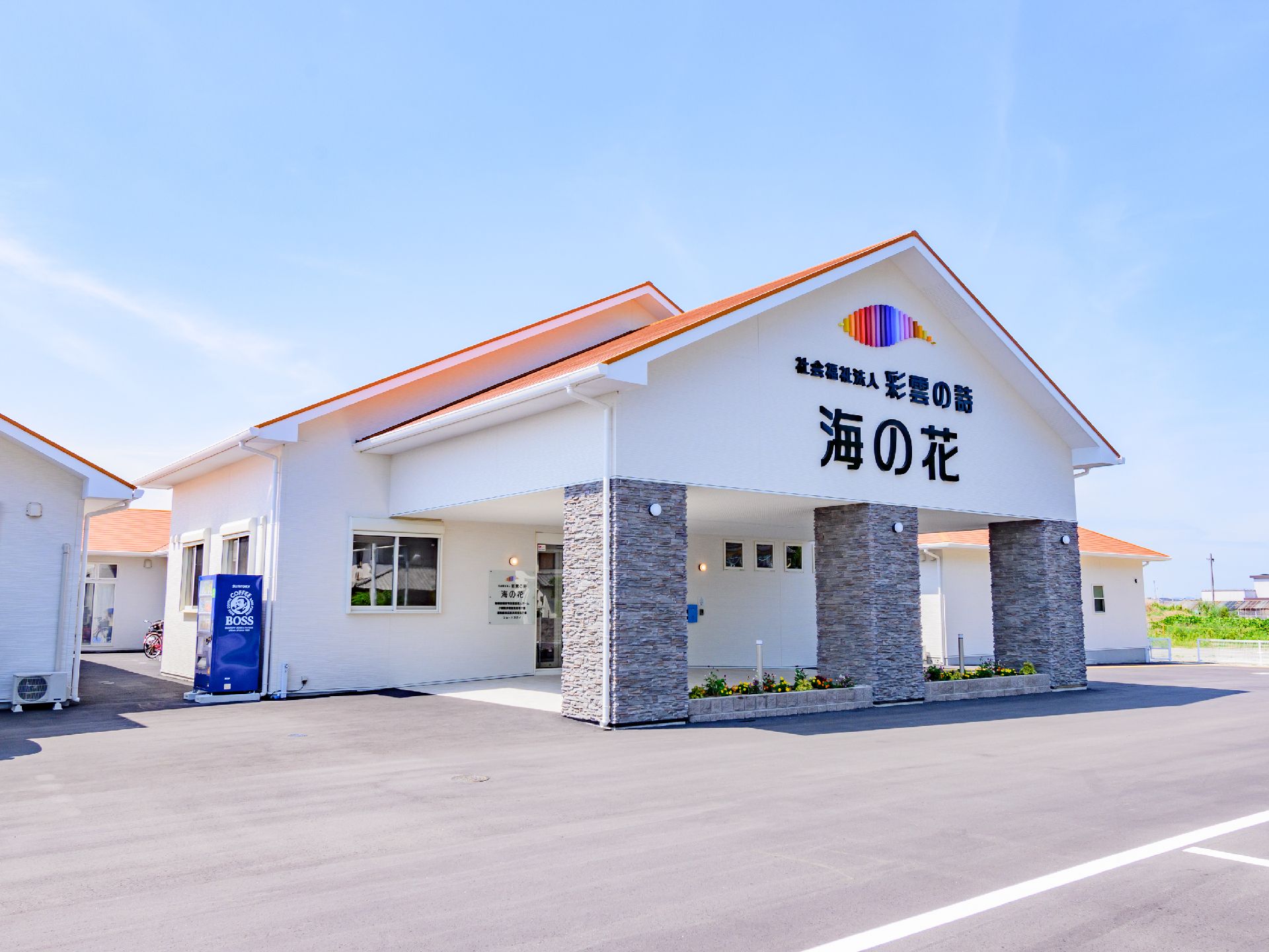 アスファルトに接した白い外観で三角形の屋根を設けた建物