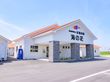 アスファルトに接した白い外観で三角形の屋根を設けた建物