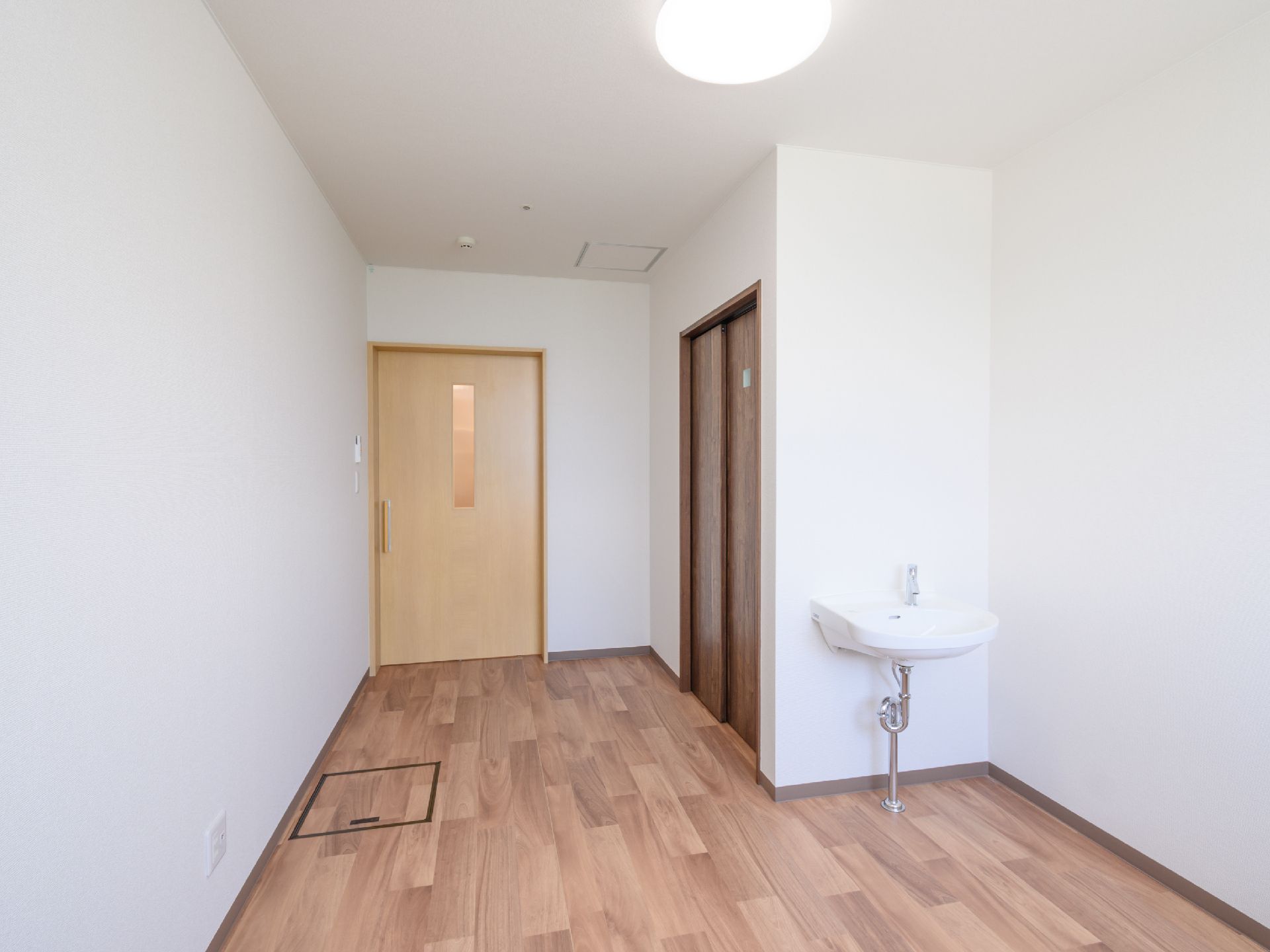 白い壁の洗面器が配置された部屋