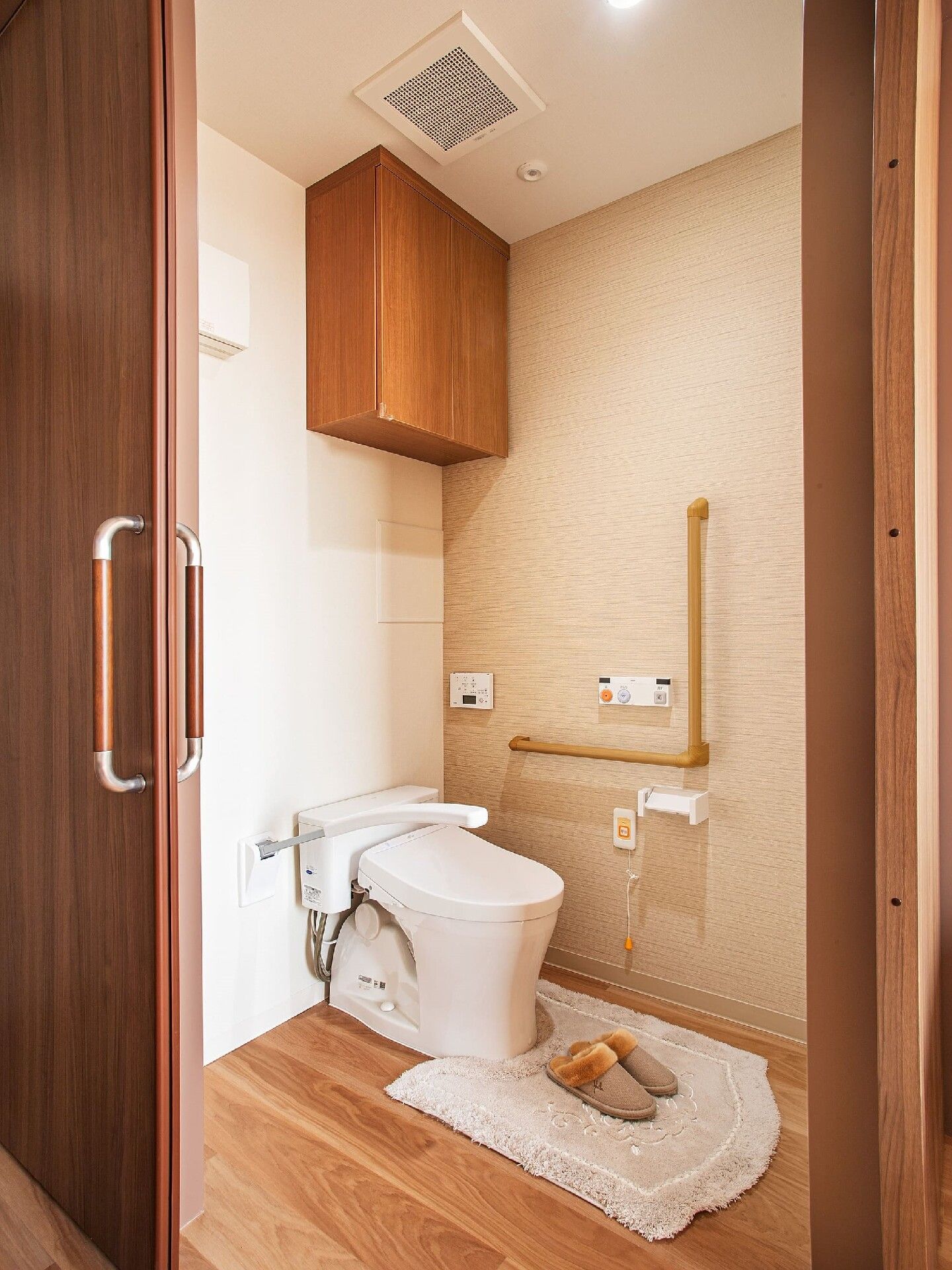段差のないトイレにはエル字型の手すりやオレンジの呼び出しボタンが付いている。