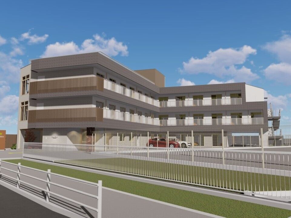 各フロアにベランダが付いた3階建ての建物はエル字型で、敷地内に庭があり、駐車場も付いている。