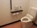 手すりや呼び出しボタンも設置されたトイレは広く、便座にはふたが付いていない。