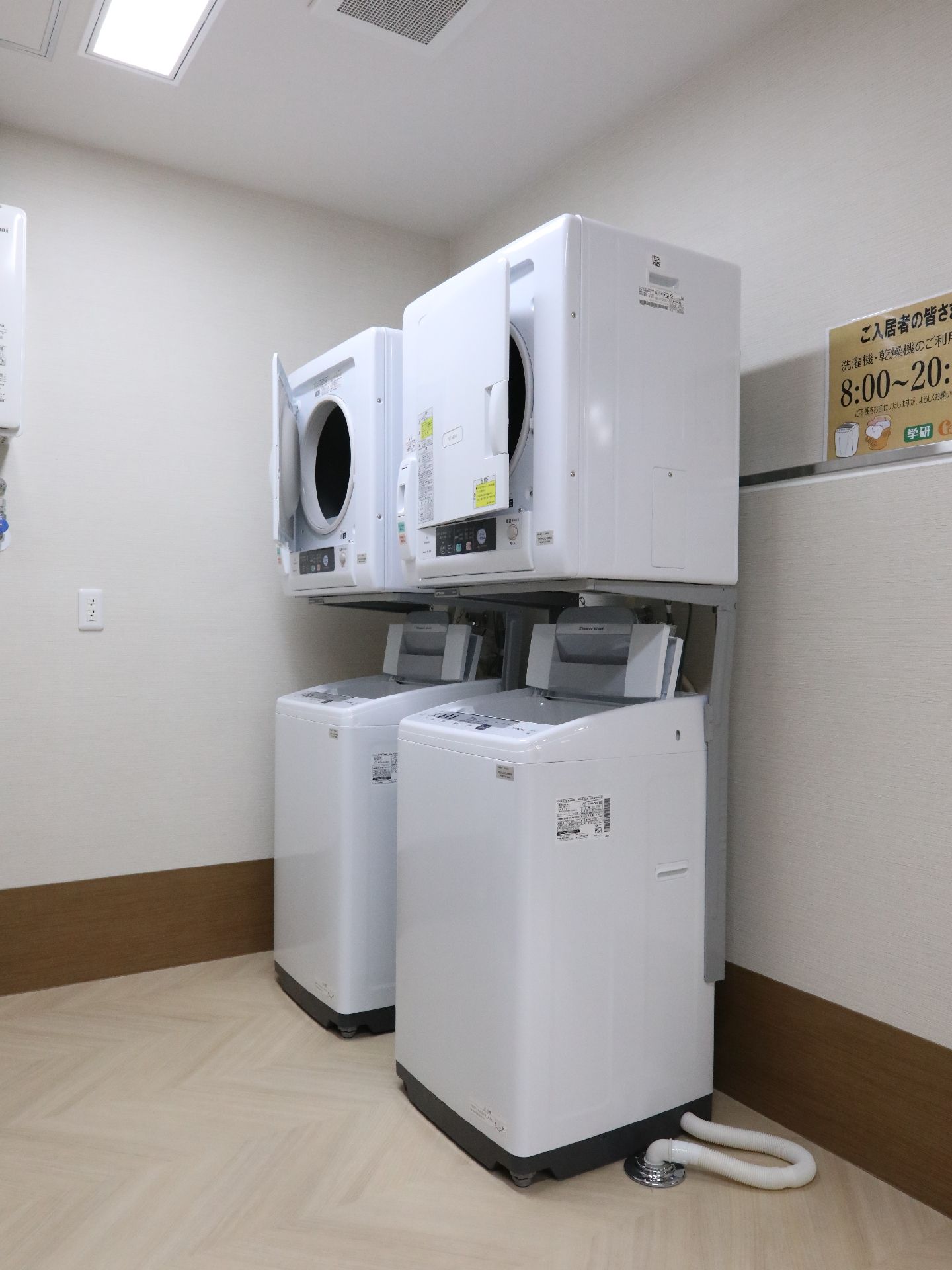 白い洗濯機と乾燥機が置かれている洗濯室
