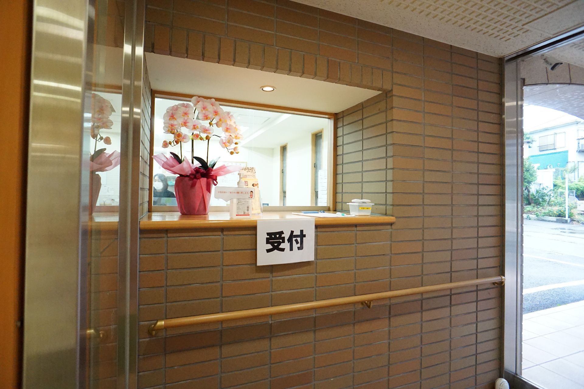風除室のレンガ調の壁の受付窓口